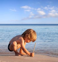 Picture of Little Boy at the Beach Writing in the Sand